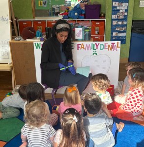 Dental professional teaching a small group of young children about family dentistry